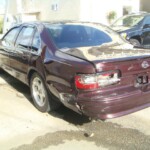 Before and after photographs of a damaged Chevy Impala that was repaired by Elite Paint & Body Shop in West Palm Beach, Florida.